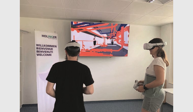 Fig. 5 Projekt-Meeting mit VR-Brille, die beiden Controller dienen der Navigation im Modell, auf einem zusätzlichen Bildschirm wird das Sichtfeld der VR-Brille für die anderen Teilnehmer gestreamt.