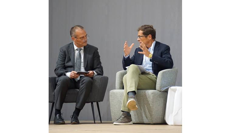 Auf dem Podium: Moderator Frank Schürch, und Nationalrat Roger Köppel.