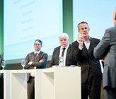 An der Podiumsdiskussion gingen die Teilnehmenden unter anderem der Frage nach, ob Fernwärme in Zukunft zur Grundversorgung zählen soll, so wie Wasser oder Strom. V.l.: Andrea Grüniger, Reto Burkard, Othmar Reichmuth, Matthias Sulzer von der Empa, der als Moderator agierte, und Birger Lauersen. (Quelle: Thermische Netze Schweiz/© Manu Friederich) An der Podiumsdiskussion gingen die Teilnehmenden unter anderem der Frage nach, ob Fernwärme in Zukunft zur Grundversorgung zählen soll, so wie Wasser oder Strom. V.l.: Andrea Grüniger, Reto Burkard, Othmar Reichmuth, Matthias Sulzer von der Empa, der als Moderator agierte, und Birger Lauersen. (Quelle: Thermische Netze Schweiz/© Manu Friederich)