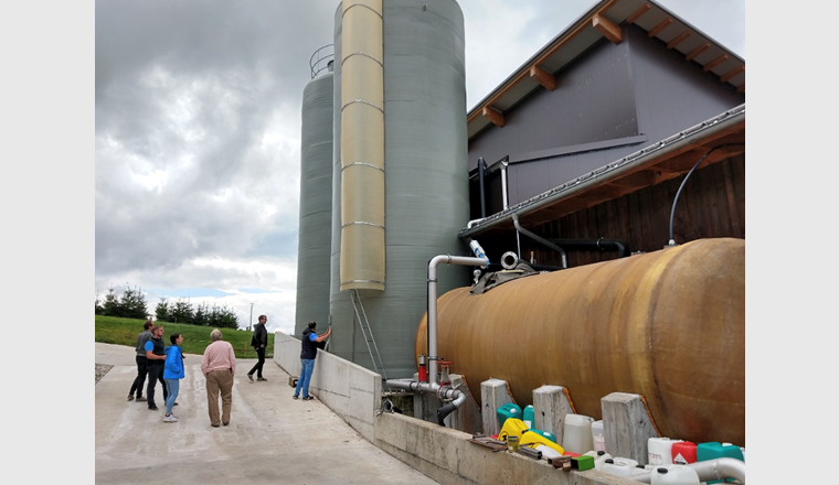 Die 1995 erbaute Biogasanlage in Süderen (Kanton BE). Bei der kürzlich erfolgten Erneuerung der Anlage wurden zwei Tanks (Bildhintergrund) errichtet, in denen die Hydrolyse – der erste der vier Prozessschritte der Vergärung – gesondert stattfindet. Mit dieser geänderten Prozessführung konnte der Durchsatz der Biogasanlage deutlich erhöht werden, wie Wolfgang Merkle (ZHAW) an der Bioenergieforschungs-Tagung in Bern berichtete. (Bild: ©ZHAW)