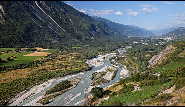 Vista dalla chiesa di Varen della pianura alluvionale di Pfynwald con il Rodano (guardando a valle), i banchi di ghiaia e le terrazze di ghiaia asciutta con la pineta. (Foto: Jan Ryser/BAFU)