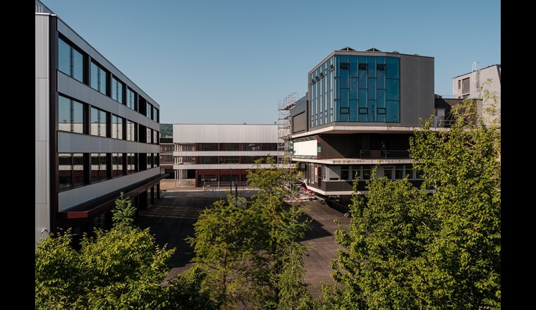 Die neuen Fassaden – links das Labor-, hinten das Multifunktionsgebäude – spiegeln die Dynamik des bestehenden NEST-Gebäudes (rechts) wider. (Bild: Empa)
