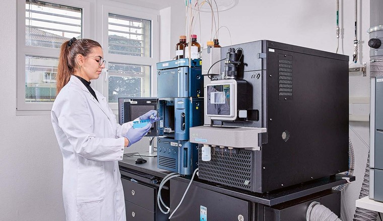 Fig. 3 La chimiste Doriane Meyer place des échantillons dans l'instrument ACQUITY UPLC Class I (à gauche en bleu; système LC); à droite: Xevo TQ Absolute (en gris; triple quadrupole mass
spectrometer) de la marque Waters. (Image : Jeremy Bierer)