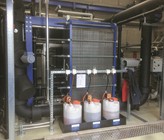 Plattenwärmetauscher und Reinigungsanlage. Im Vordergrund sind die Reinigungs- und Desinfektionsflüssigkeiten für die automatische Spülung der Wärmetauscher zu sehen. Plattenwärmetauscher und Reinigungsanlage. Im Vordergrund sind die Reinigungs- und Desinfektionsflüssigkeiten für die automatische Spülung der Wärmetauscher zu sehen.